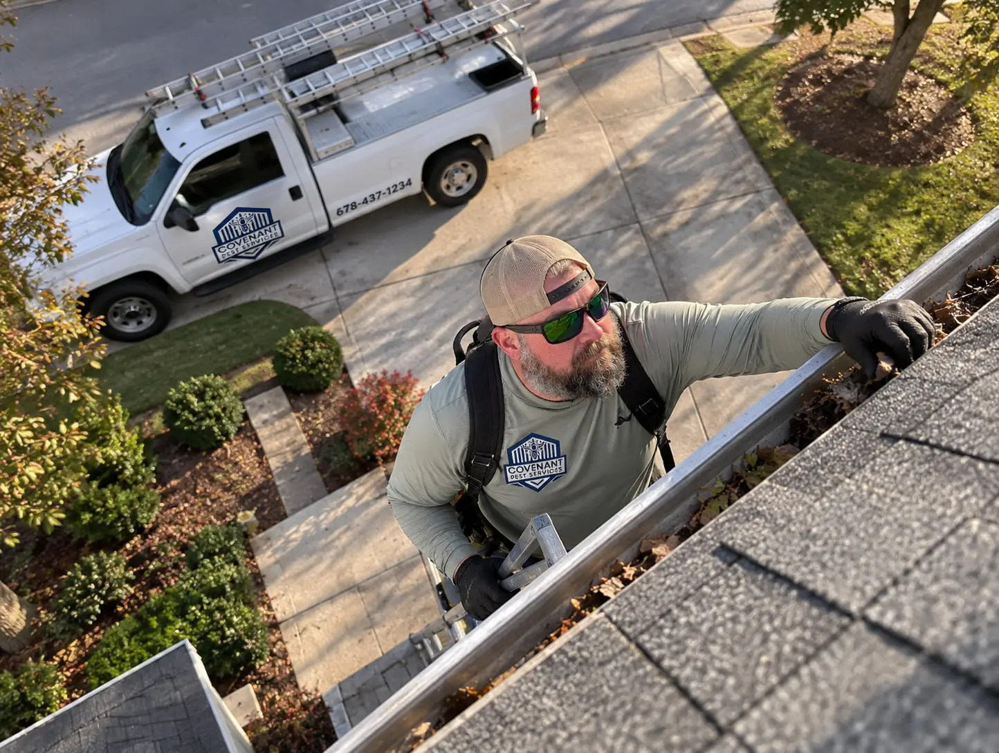 Covenant Pest Services technician inspecting a roofline and gutter for wildlife entry points